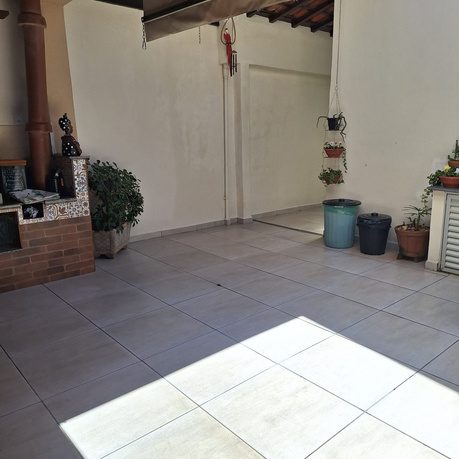 Quintal amplo coberto com churrasqueira e plantas